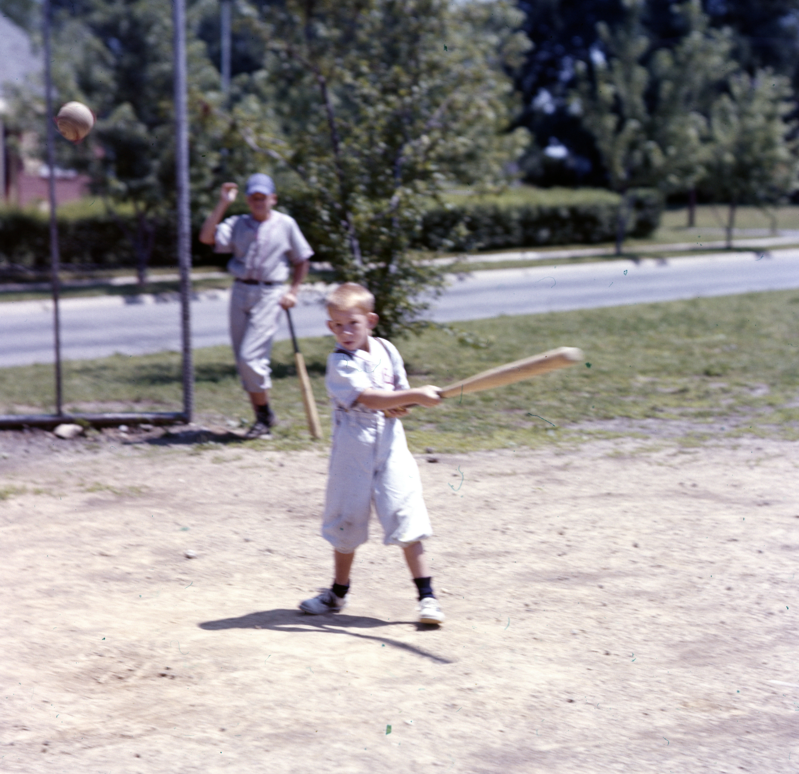 Color photo of child swinging bat
