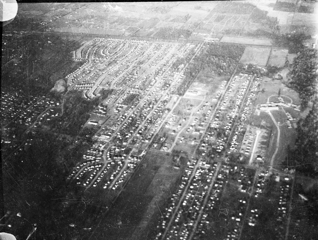 Black and white aerial photograph of streets and homes