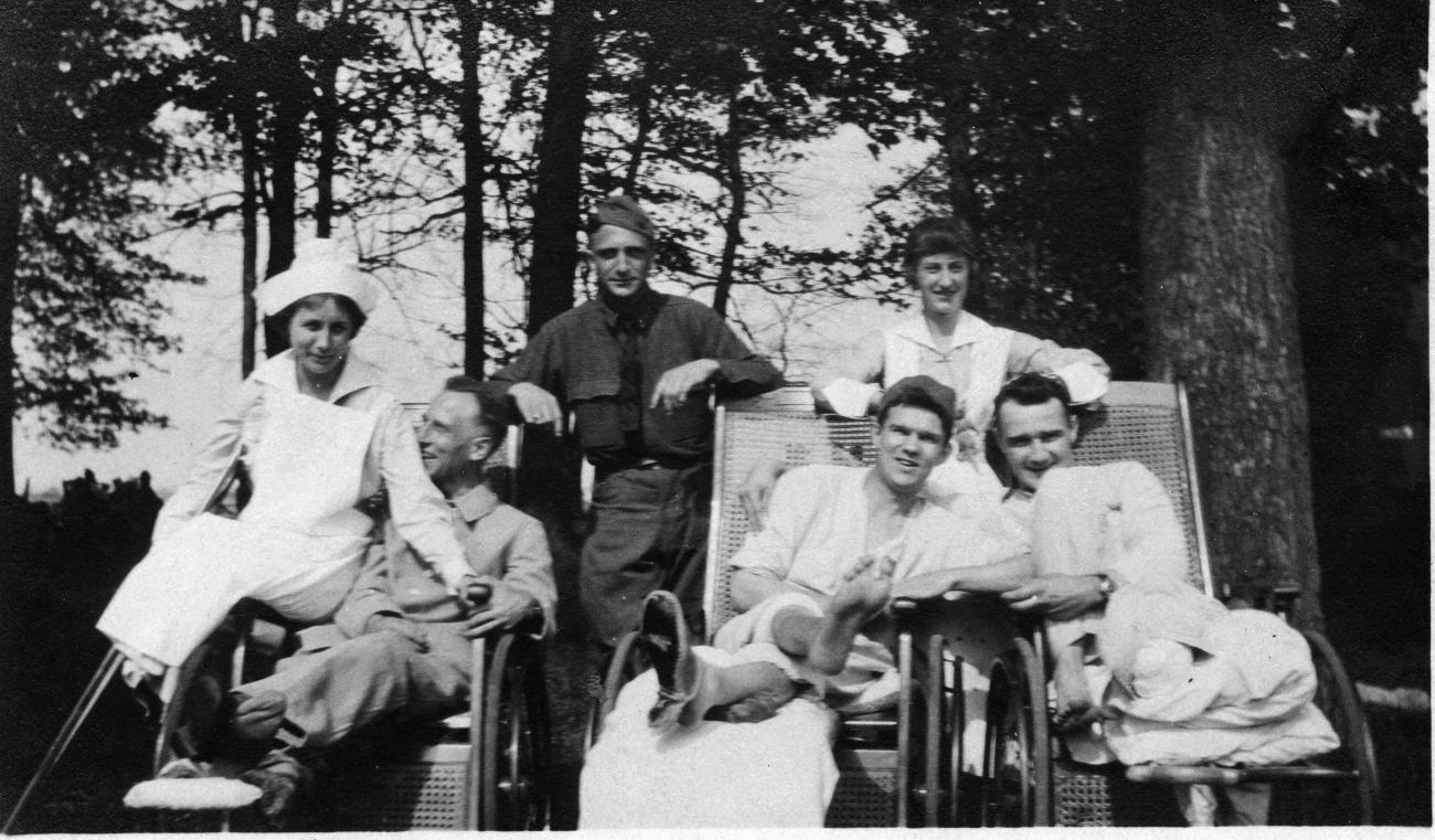 Black and white photograph of two World War I nurses and four soldiers seated and standing