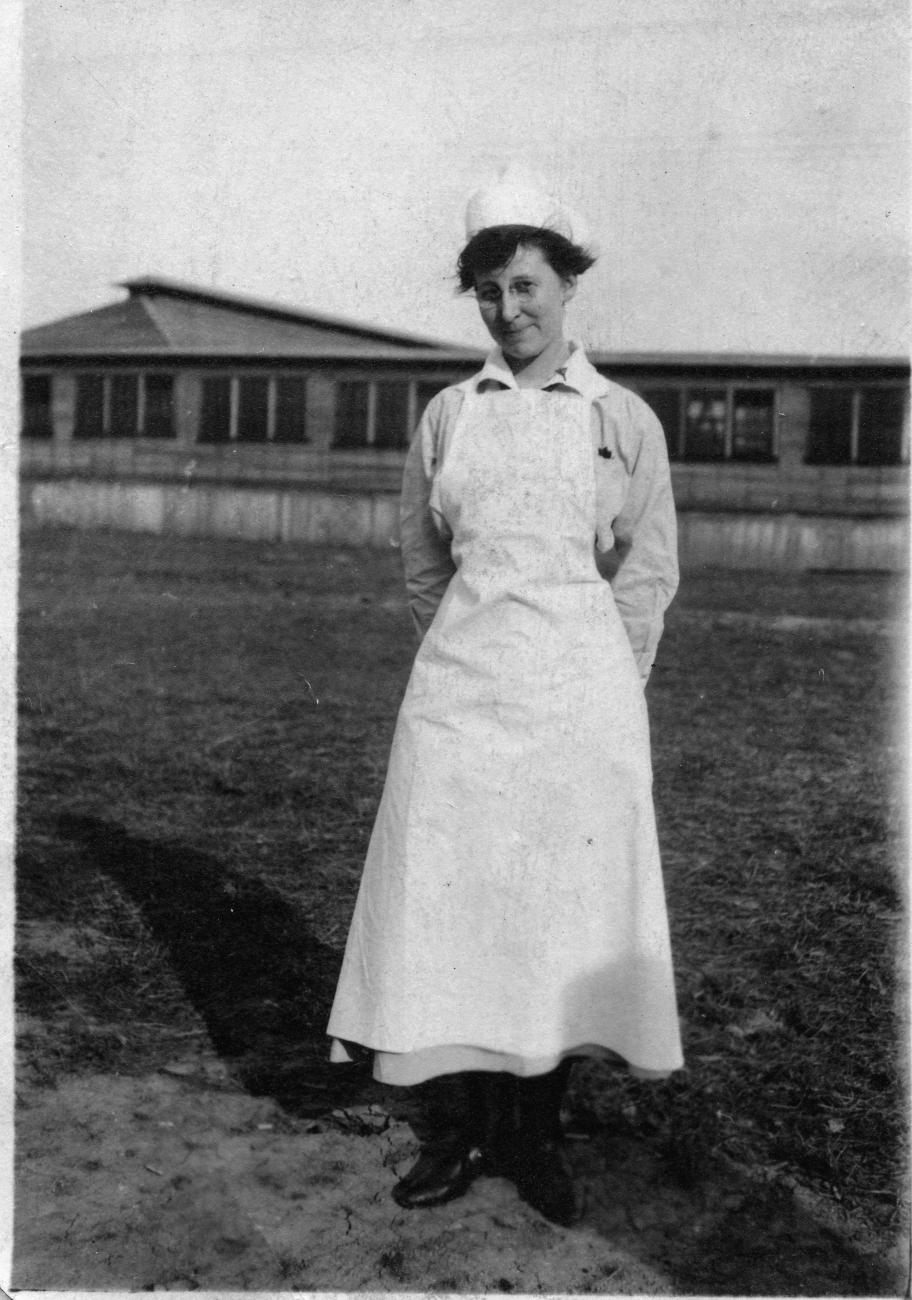 Harriet Elizabeth Putman Standing in Field in Front of Building