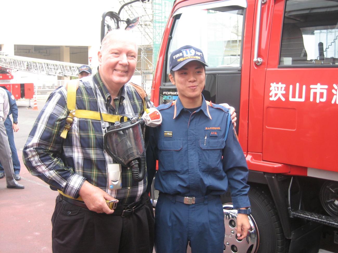 Photograph of Harvey Minton with a firefighter in Sayama, Japan