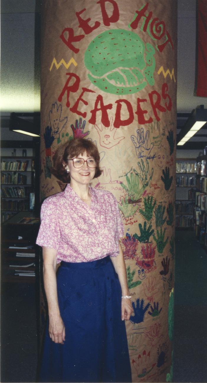 Photograph of Jo Osborne with "Red Hot Readers" Pillar