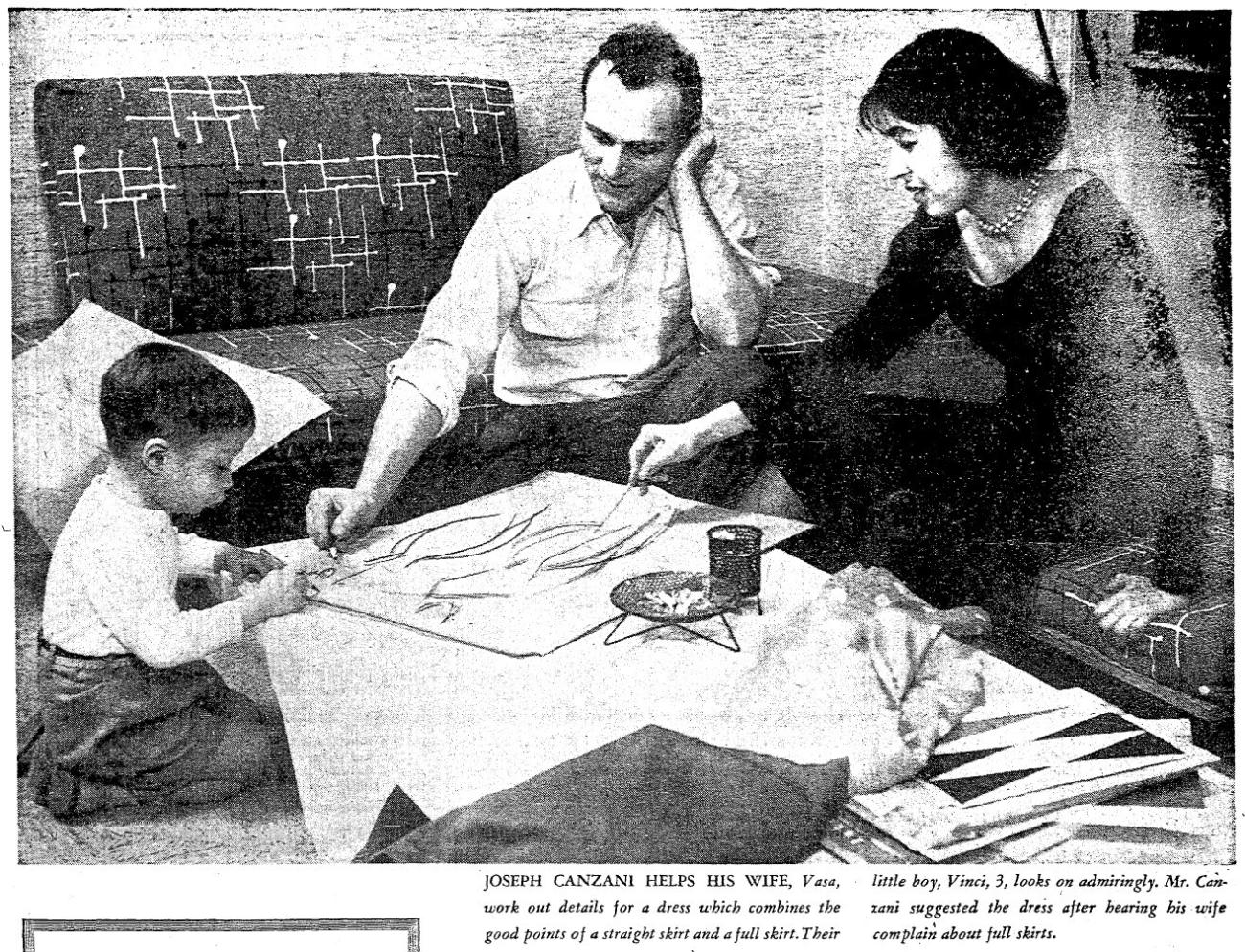 Black and white image of a child and two adults kneeling around and working on a drawing on a low platform