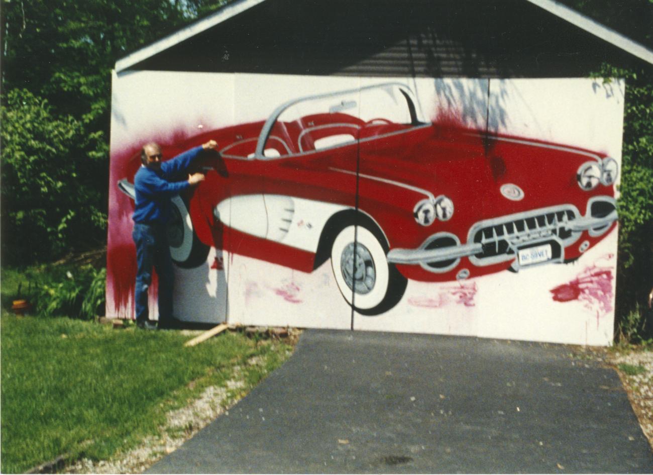 Photograph of William (bc) (Bill) Collins with his Painting of a Red Corvette