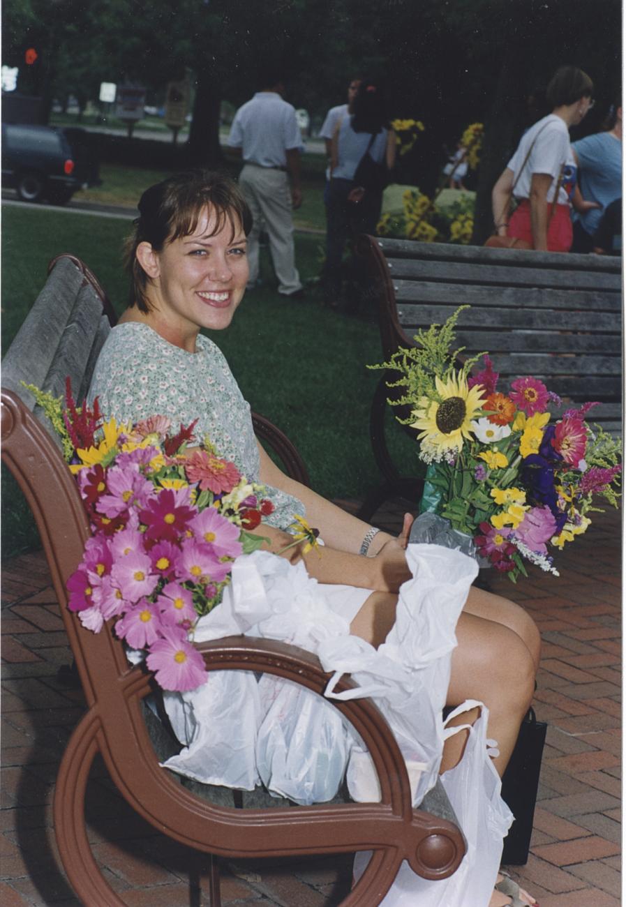 Shopper Sitting on Bench with Flowers at the Worthington Farmer's Market