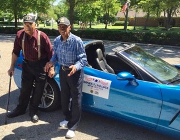 Herbert McGee and Moses Eldridge standing in front of blue convertible