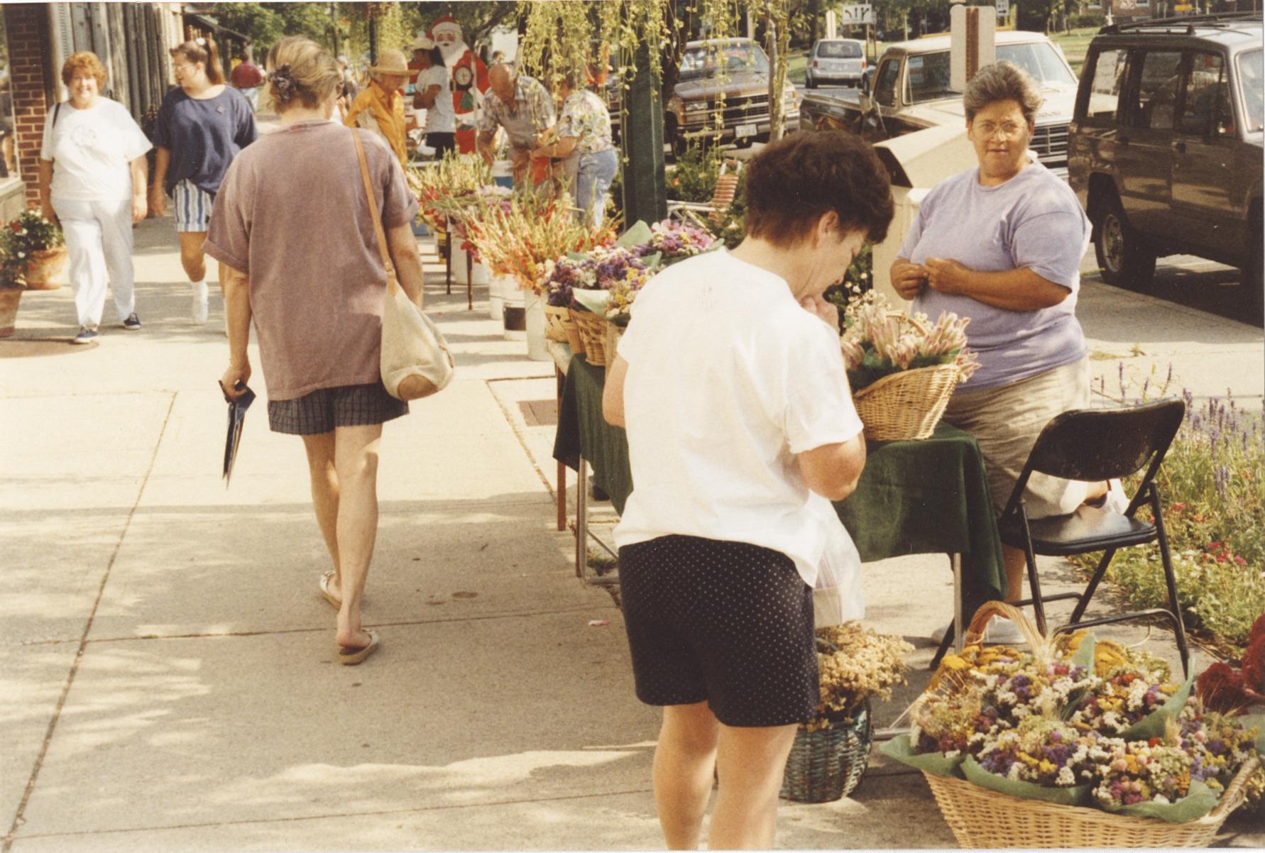 Shopper Viewing Dried Flower Arrangements at the Worthington Farmer's Market