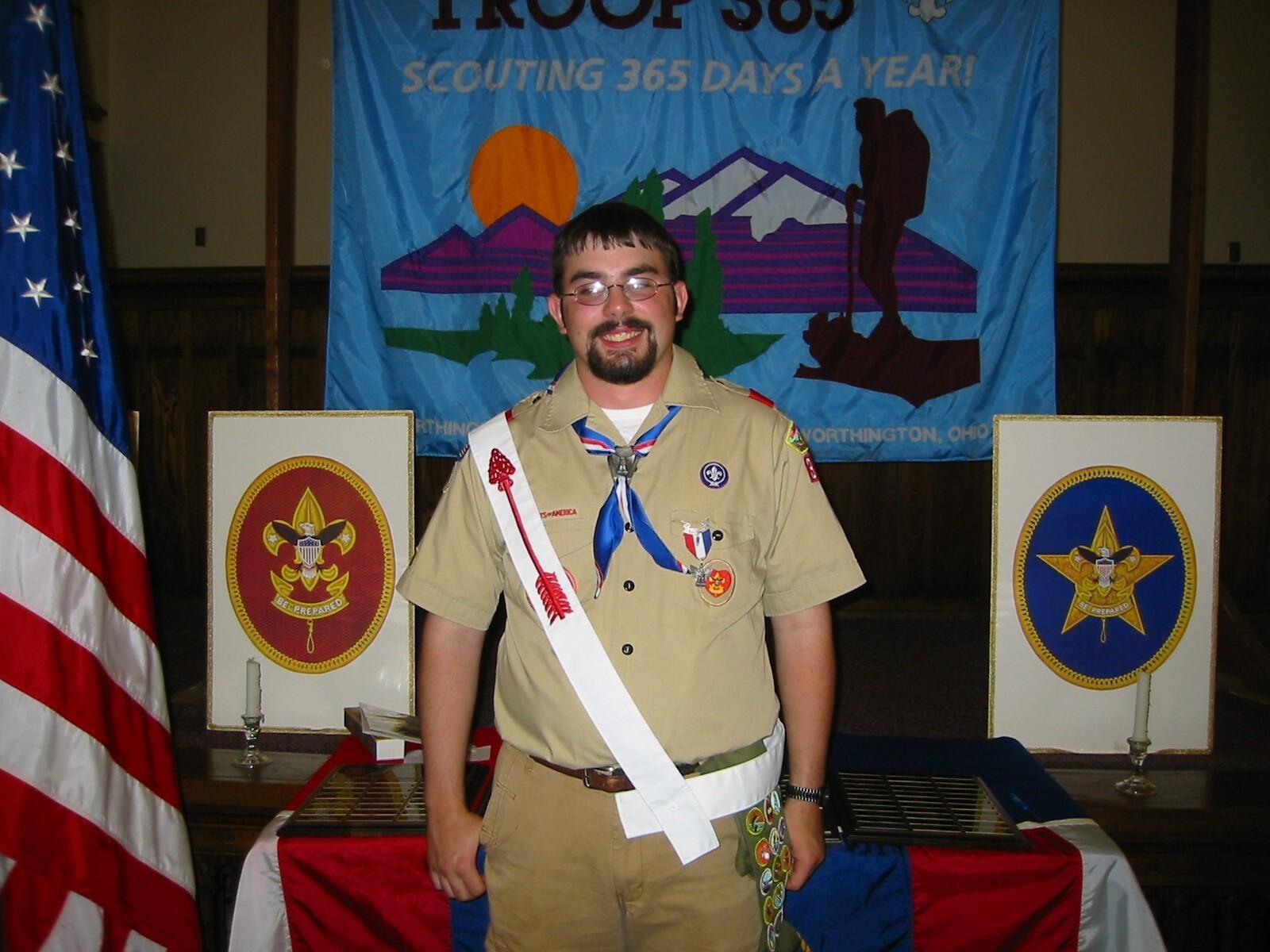 Volunteer Joe Miracle standing in Boy Scout uniform, smiling at camera
