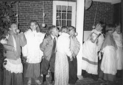 Children attempt to bite apples suspended from strings
