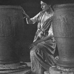 Black and white photo of woman kneeling between two large urns