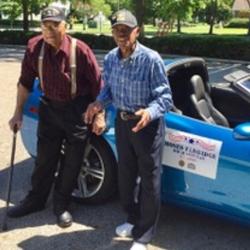 Herbert McGee and Moses Eldridge standing in front of blue convertible