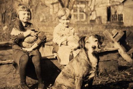 Two children with dog and chicken
