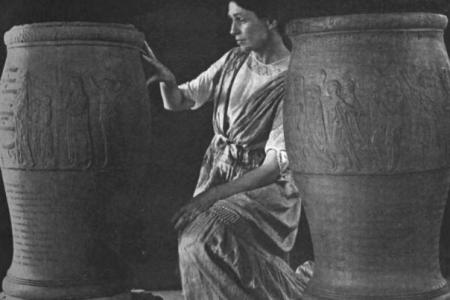 Black and white photo of woman kneeling between two large urns