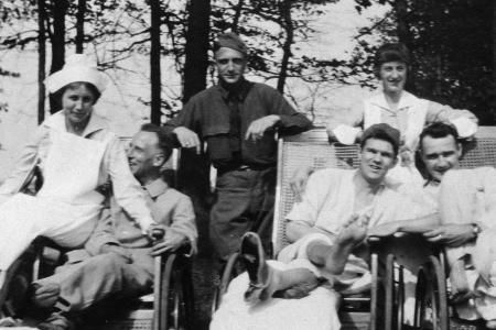 Black and white photograph of two World War I nurses and four soldiers seated and standing