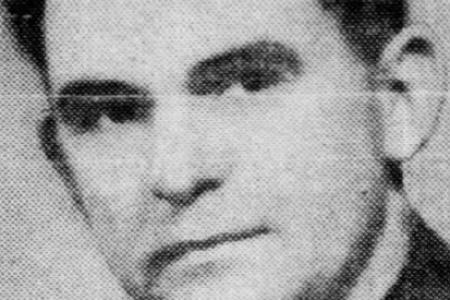 Black and white reproduction of a portrait photo featuring a man in suit looking at camera with neutral expression