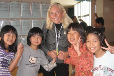 Photograph of Anne Brown with elementary school students in Sayama, Japan