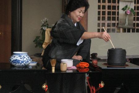 Photograph of a woman in Sayama, Japan preparing green tea
