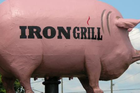 Side View of the Pig Sign in Front of Iron Grill Barbeque & Brew